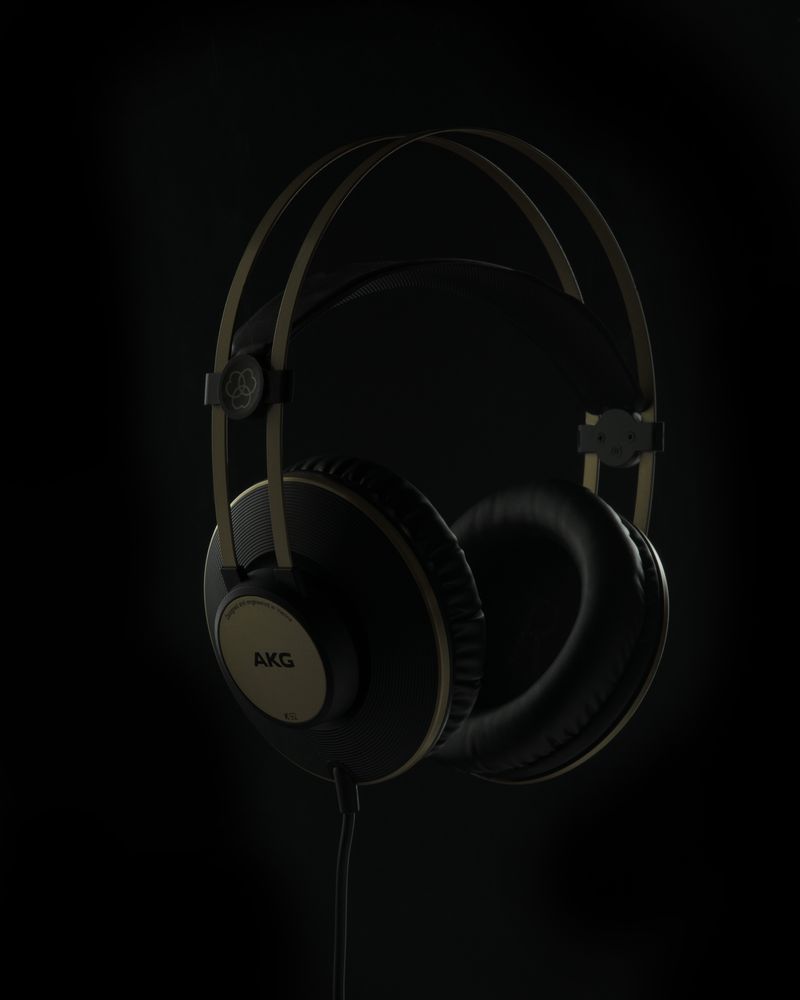 Low-key creative product shot of AKG K92 headphones lit against a black background