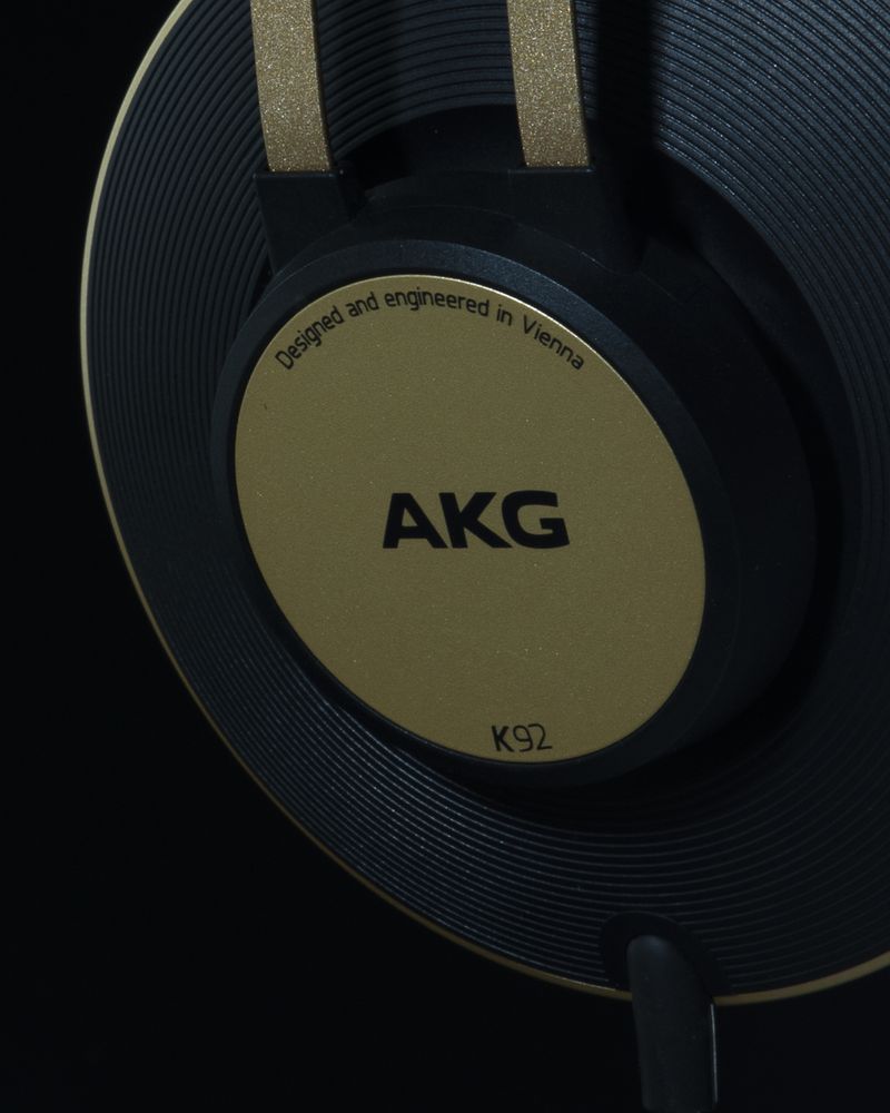 Close-up detail of a gold AKG K92 headphone ear cup against black, shot for an e-commerce listing